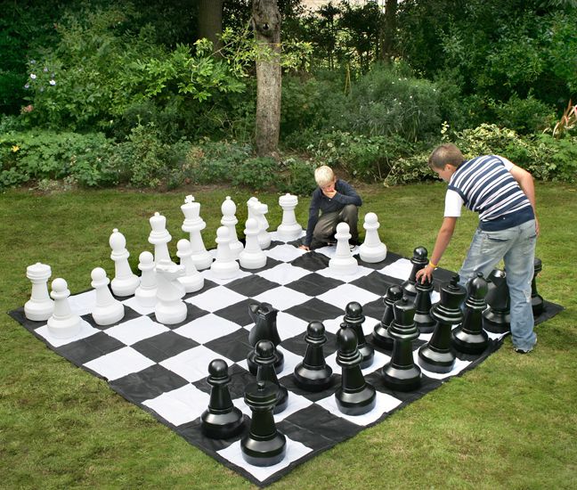 Feche peças grandes e tabuleiro de xadrez gigante de xadrez de rua no  parque